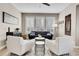 Comfortable living room featuring white armchairs and a navy sofa at 5965 Topaz Vista Pl, Castle Pines, CO 80108