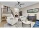 Spacious living area with two armchairs and a large TV above the fireplace at 5965 Topaz Vista Pl, Castle Pines, CO 80108