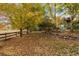 Spacious backyard with mature trees in full autumn foliage and a wooden fence at 15904 W 58Th Ave, Golden, CO 80403
