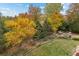 Backyard patio with outdoor seating amid mature trees and fall colors at 15904 W 58Th Ave, Golden, CO 80403