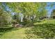 Lush green backyard featuring mature trees providing shade and a retaining wall at 15904 W 58Th Ave, Golden, CO 80403