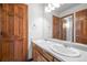 Bright bathroom featuring double sinks, wood cabinets, and a large mirror reflecting a doorway at 15904 W 58Th Ave, Golden, CO 80403