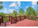 Spacious wooden deck with red railings, offering scenic views of the surrounding green landscape at 15904 W 58Th Ave, Golden, CO 80403