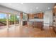 Open kitchen boasts wood floors, granite counters, wooden cabinets, and access to a deck with treetop views at 15904 W 58Th Ave, Golden, CO 80403