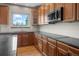 Elegant kitchen featuring wooden cabinetry, granite counters, modern appliances, and lots of natural light at 15904 W 58Th Ave, Golden, CO 80403