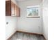 Functional laundry room featuring upper cabinets, vinyl flooring, and a window for natural light at 15904 W 58Th Ave, Golden, CO 80403