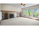 Cozy living area with stone fireplace, built-in shelving, large windows with a treed outlook and a ceiling fan at 15904 W 58Th Ave, Golden, CO 80403