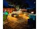 Beautiful backyard with a stone fire pit, ambient lighting and lush landscaping for outdoor entertaining at 4779 S Bannock St, Englewood, CO 80110