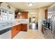 Kitchen with wood cabinets, stainless appliances, tile floors, and open floor plan at 4779 S Bannock St, Englewood, CO 80110