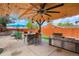 Beautiful covered outdoor kitchen area with a built-in grill and bar seating for entertaining at 4779 S Bannock St, Englewood, CO 80110