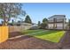 Large backyard features a manicured lawn, a wooden fence, and a view of the multi-level home at 2426 S Acoma St, Denver, CO 80223