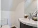 Cozy half bathroom with hardwood floors, pedestal sink, and a mirror at 2426 S Acoma St, Denver, CO 80223
