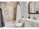 Clean bathroom featuring a tub shower with decorative tiles and a modern vanity at 2426 S Acoma St, Denver, CO 80223