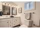 Modern bathroom features double sinks, decorative mirrors, and updated fixtures at 2426 S Acoma St, Denver, CO 80223