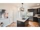Modern kitchen features a quartz island, stainless steel appliances, and black cabinets at 2426 S Acoma St, Denver, CO 80223