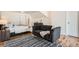 Stylish main bedroom with seating area, patterned rug, and ensuite access at 2426 S Acoma St, Denver, CO 80223