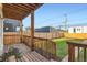 Covered deck features a wooden ceiling, railing, and an open view of the fenced yard at 2426 S Acoma St, Denver, CO 80223