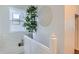 Bright stairwell landing with white banisters and a decorative plant next to the window at 2426 S Acoma St, Denver, CO 80223