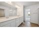 Bathroom featuring double sinks, quartz countertops, and wood-look flooring at 45921 Wood Thrush Ave, Bennett, CO 80102
