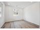 A light-filled bedroom boasts neutral paint, recessed lighting, and gorgeous light wood floors throughout at 45921 Wood Thrush Ave, Bennett, CO 80102