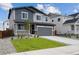 A modern two-story home with a well-kept lawn, driveway, attached two-car garage, and attractive blue-gray siding at 45921 Wood Thrush Ave, Bennett, CO 80102