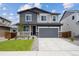 Beautiful two-story home boasts a manicured lawn, a two-car garage, and attractive gray and blue siding at 45921 Wood Thrush Ave, Bennett, CO 80102