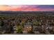 Aerial view of a neighborhood at sunset featuring homes, trees, and the mountain range at 13131 Pennsylvania St, Thornton, CO 80241