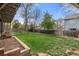 Green backyard featuring a garden, lush grass, and a wooden fence for privacy at 13131 Pennsylvania St, Thornton, CO 80241