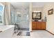 Elegant bathroom featuring a soaking tub, glass shower, vanity with ample storage, and modern fixtures at 13131 Pennsylvania St, Thornton, CO 80241