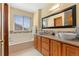 Inviting bathroom features double sinks, granite countertops, tub and a view of outside at 13131 Pennsylvania St, Thornton, CO 80241