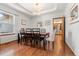 Bright dining room with hardwood floors, tray ceilings, a modern chandelier, and views into the kitchen at 13131 Pennsylvania St, Thornton, CO 80241