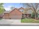 Charming two-story brick home featuring a three-car garage, covered porch, and well-maintained front yard at 13131 Pennsylvania St, Thornton, CO 80241
