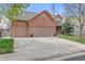 Charming two-story brick home featuring a three-car garage and a well-maintained front yard with mature trees at 13131 Pennsylvania St, Thornton, CO 80241