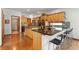 Spacious open kitchen with stainless appliances, wood cabinets, breakfast bar, and hardwood floors at 13131 Pennsylvania St, Thornton, CO 80241