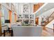 Spacious living room featuring high ceilings, a fireplace with custom shelving, and staircase access to the upper level at 13131 Pennsylvania St, Thornton, CO 80241
