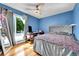 A modern bedroom with a ceiling fan, hardwood floors, and large windows at 10972 Fairfax Ct, Thornton, CO 80233