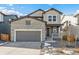 Two-story home with stone and siding exterior, gray garage door, and small front porch at 13372 E 110Th Way, Commerce City, CO 80022