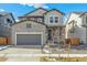 Two-story house with stone and gray siding, two-car garage at 13372 E 110Th Way, Commerce City, CO 80022