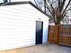 White garage with black door, next to wooden fence at 102 Jackson Dr, Firestone, CO 80520