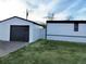 White detached garage with dark gray door at 102 Jackson Dr, Firestone, CO 80520