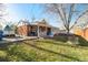 Brick house with a covered back patio, a fenced yard, and green grass offers the potential for personalized landscaping and updates at 3778 S Hooker St, Englewood, CO 80110