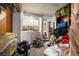 Unfinished laundry room with a side-by-side washer and dryer, overhead cabinets, and disorganized belongings needs renovation at 3778 S Hooker St, Englewood, CO 80110