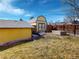 The backyard has a yellow outbuilding with a blue trim, a fence, and a garden box at 4487 S Alkire St, Morrison, CO 80465