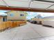 View from inside of garage, overlooking a large driveway and backyard with yellow house at 4487 S Alkire St, Morrison, CO 80465