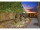 Landscaped backyard with water feature, stone pathway, and wooden fence at 4937 Tamarac St, Denver, CO 80238