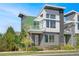 Modern two-story home with gray and green siding, and a front balcony at 4937 Tamarac St, Denver, CO 80238