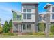 Modern two-story home with gray and green siding, and a front balcony at 4937 Tamarac St, Denver, CO 80238