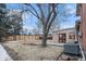 Backyard with fence, mature trees, a wood deck, and air conditioning unit outside the back of the house at 6047 Vivian Ct, Arvada, CO 80004