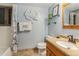 Bright bathroom featuring a tub with shower, decorative wall art, and a vanity with warm wood tones at 6047 Vivian Ct, Arvada, CO 80004