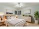 Stylish bedroom with a modern bed frame, neutral bedding, decorative pillows and plants, and light-filled windows at 6047 Vivian Ct, Arvada, CO 80004